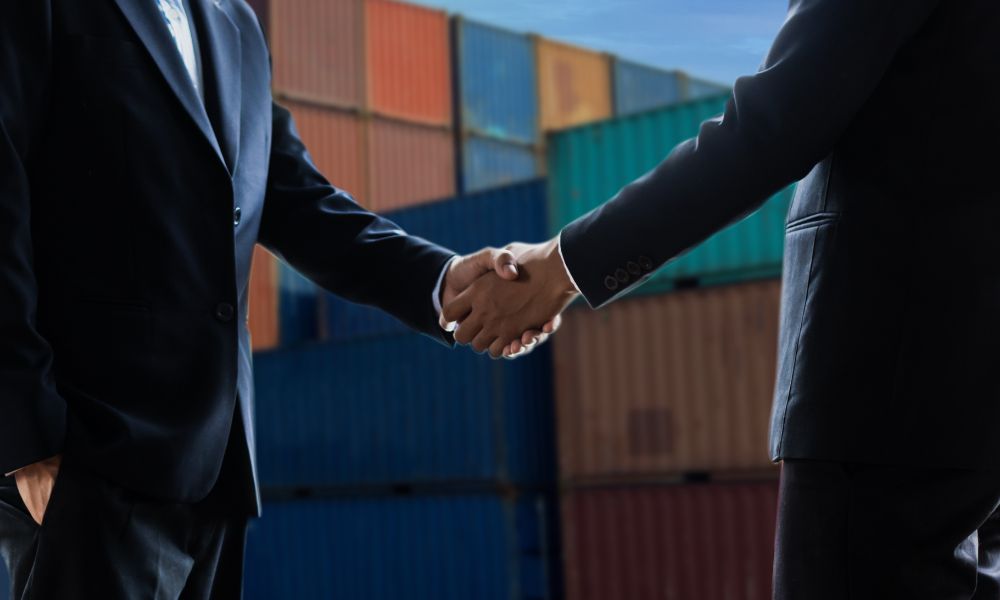 Two business partners handshake at port